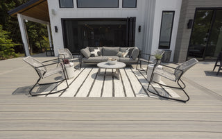Voyage Decking in Tundra with furniture and outdoor rug with white house