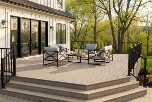 Composite deck with furniture and a view of trees and a house.