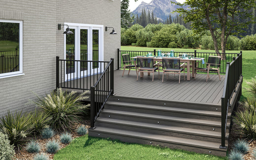 Composite deck with furniture and steps leading to a house with mountains in the background