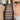 Outdoor staircase made of composite decking with black metal railings, shown between a tan wooden fence and a peach-colored house exterior.